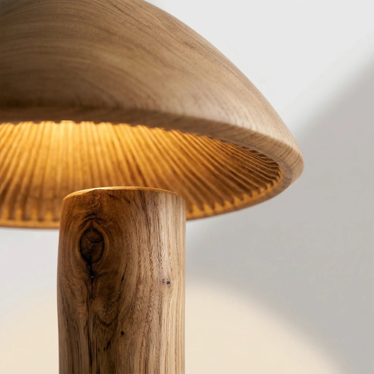 Mushroom floor lamp with wooden stem and warm glowing sculpted wood shade