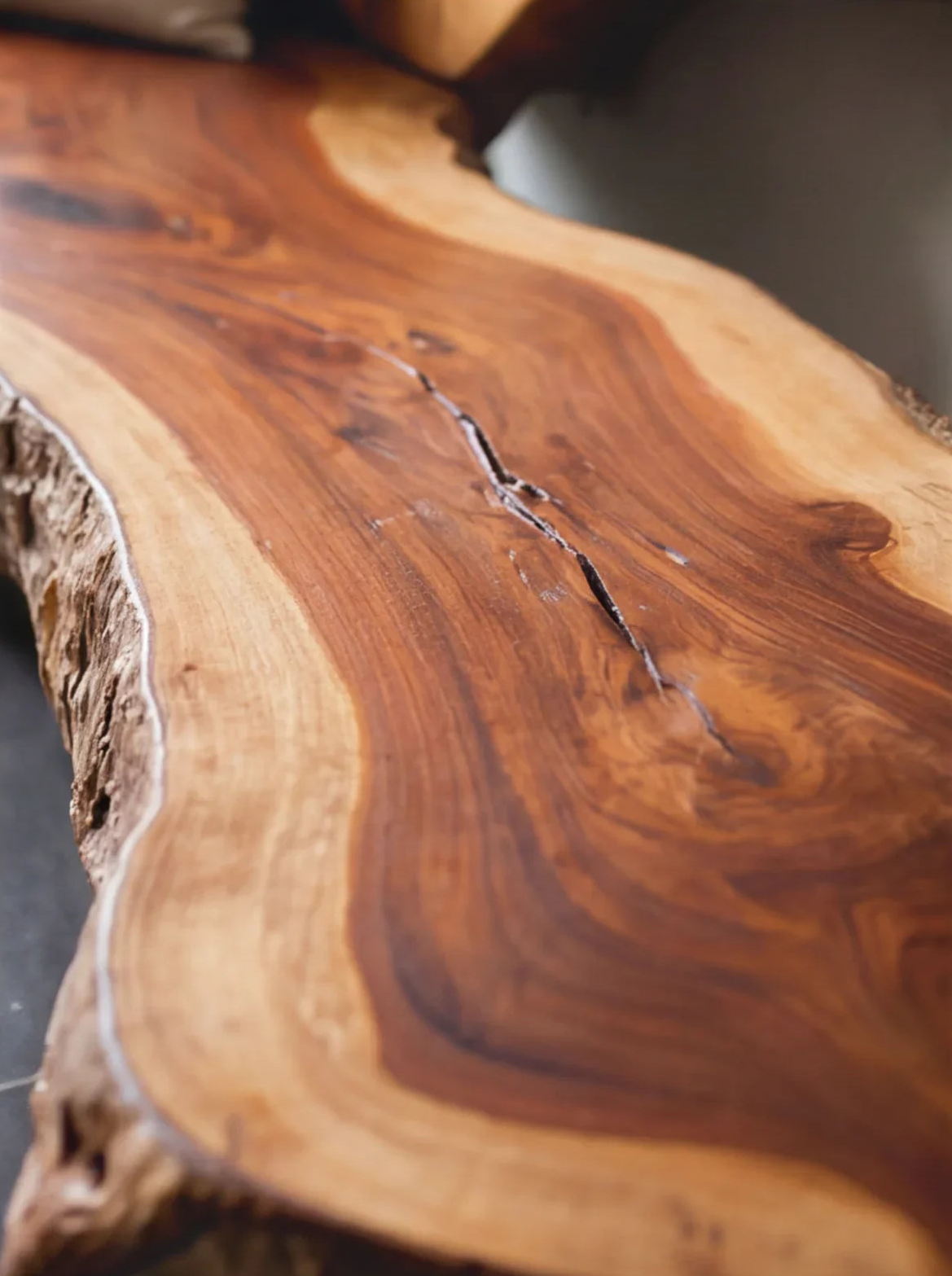 Close-up of a live edge solid wood table with natural grain and organic shape