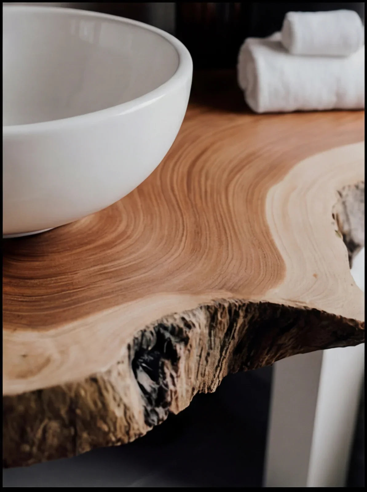 Close-up of a live edge solid wood vanity with a white bowl sink and folded towels