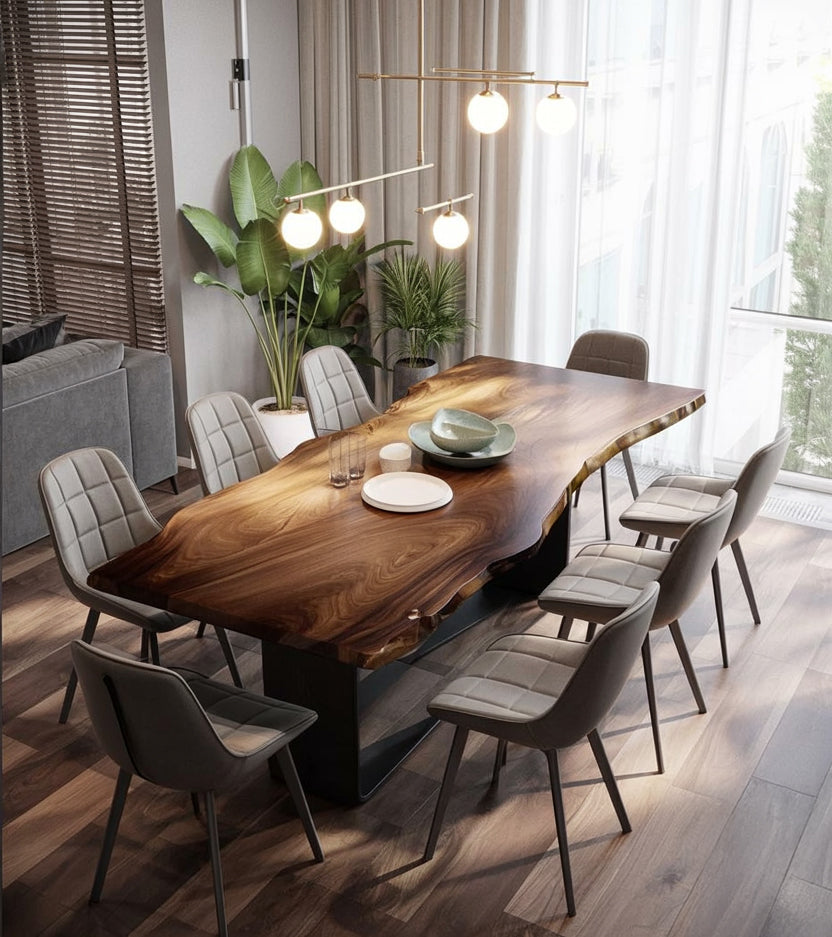 Modern dining room with live edge wooden table, eight gray upholstered chairs, and pendant lights