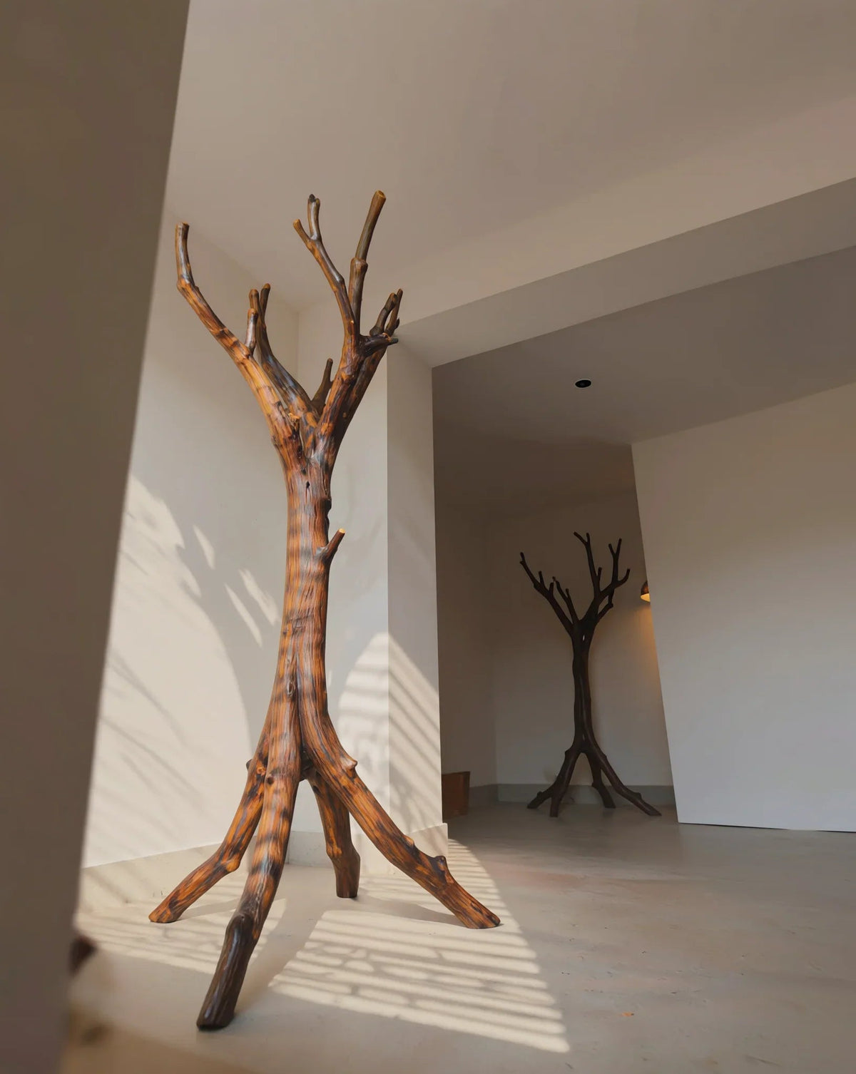 Sculpted solid wood tree bookshelf in modern minimalist room, natural live edge furniture