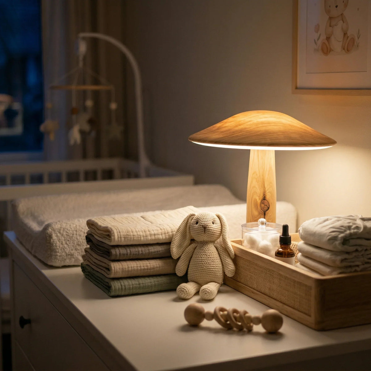 Soft modern nursery changing area with wooden lamp, stacked muslin blankets, and plush toy